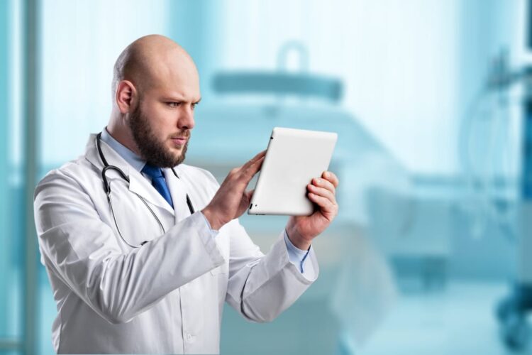 Doctor filling out check list in the clinic for healthcare data-entry