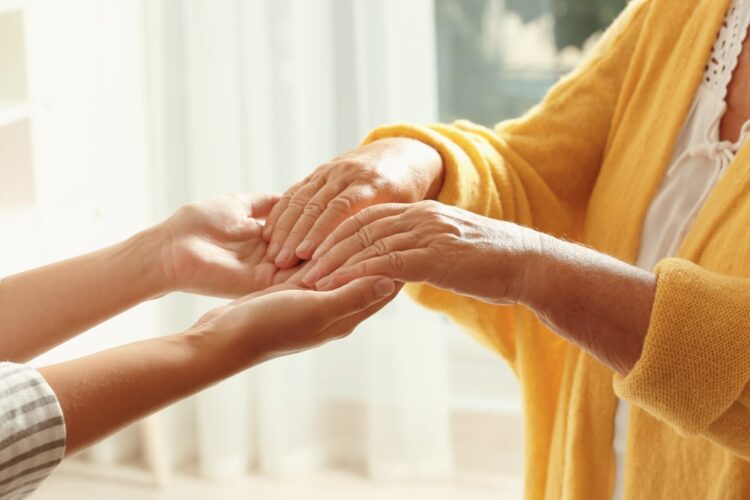 nurse holding both hands of a patient