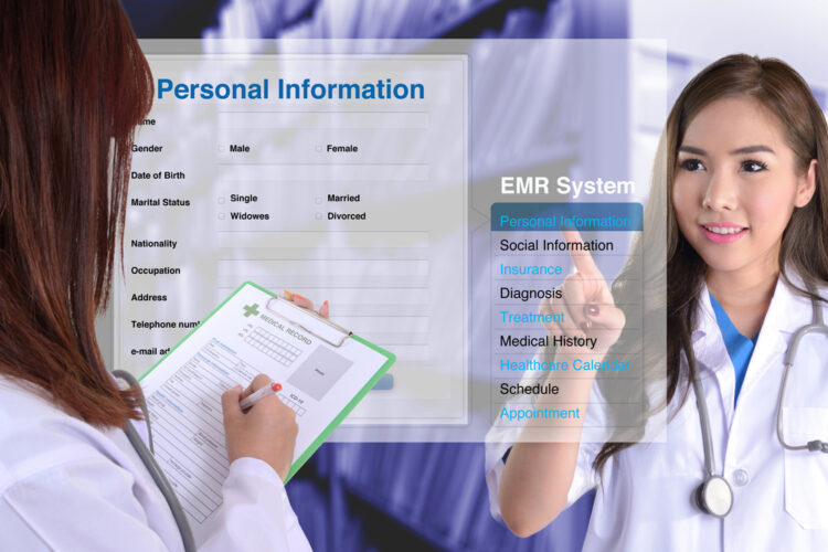 Female doctor show how to use electronic medical record while another one checking patient information by hand.
