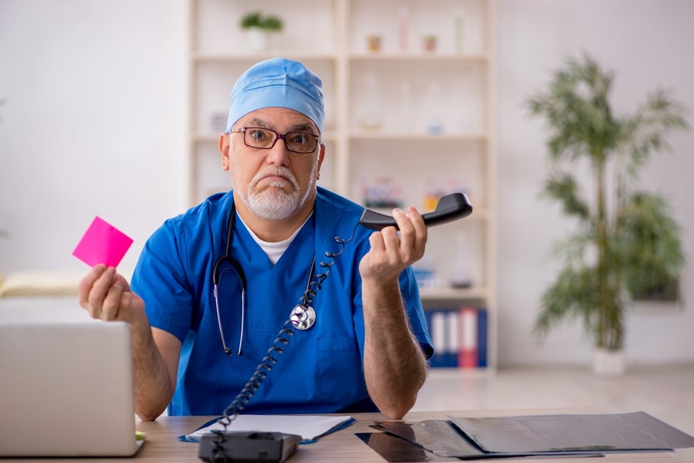 Old male doctor in telemedicine concept