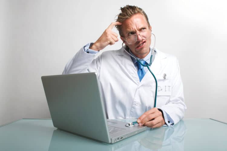 Concerned IT computer technician scratching his head listening to a laptop with his stethoscope