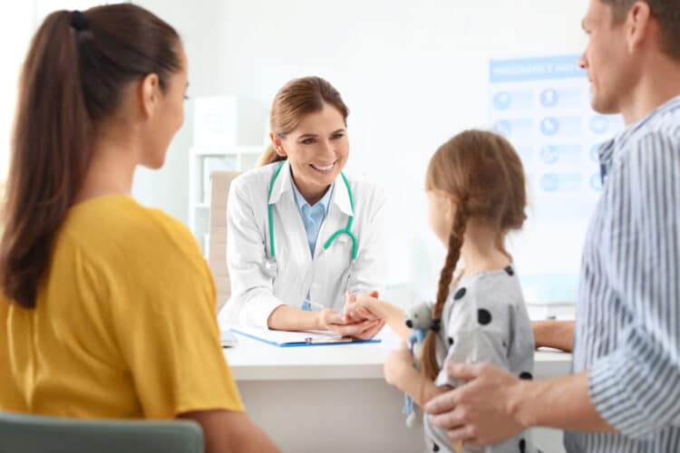 Parents with little daughter visiting children's doctor in hospital