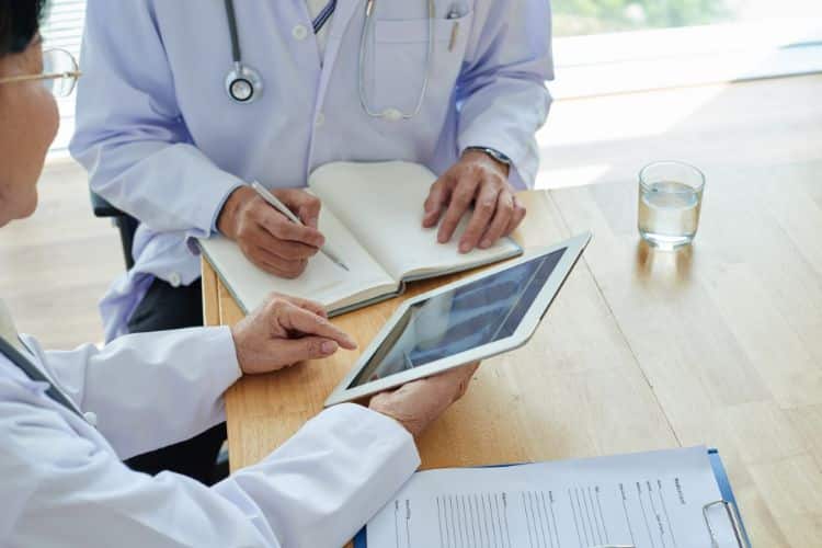 health plans a doctor with a tablet explaining to her colleague