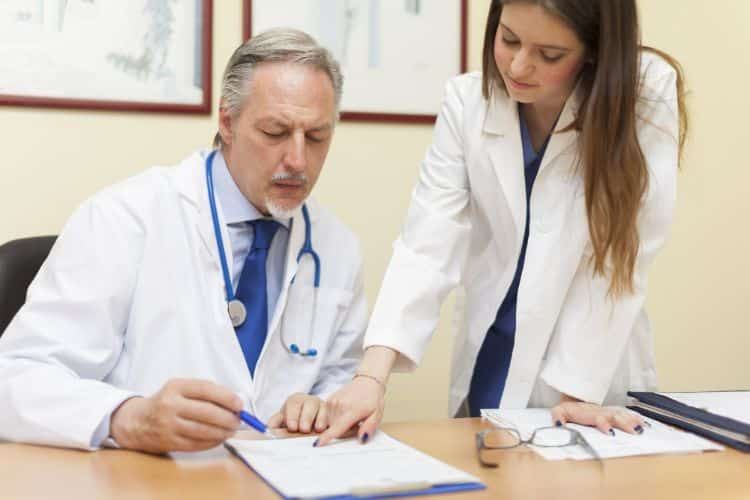 medicare beneficiaries doctor signing in a document