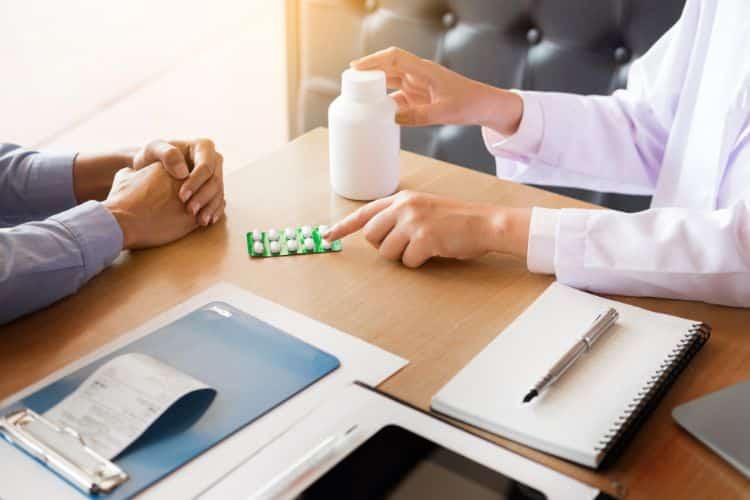 treatment guidelines hand holding tablet of drug and explain to patient