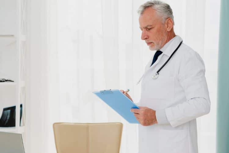 health plans doctor writing on clipboard