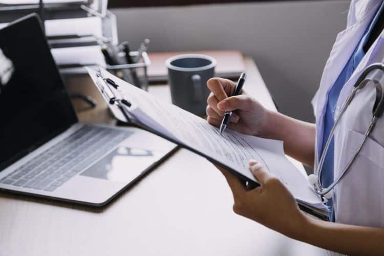 medical necessity nurse writing on a document