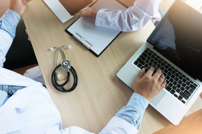 enhancing private practices with outsourcing precertification doctor using laptop