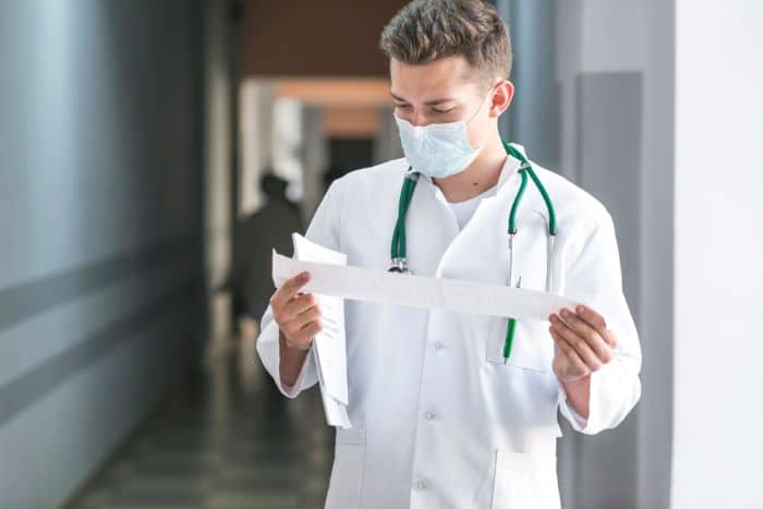 advocating prior authorization policy changes doctor looking at the paper