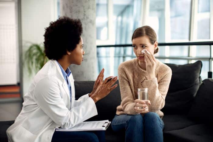 navigating prior authorization challenges doctor talking to a crying woman