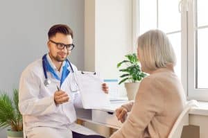 prior authorization's impact on healthcare access doctor showing the clipboard to the patient