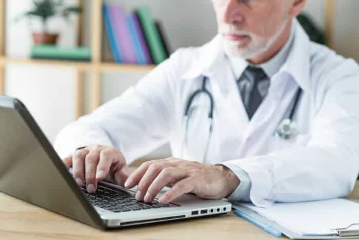 virtual medical receptionist healthcare processes, doctor using laptop