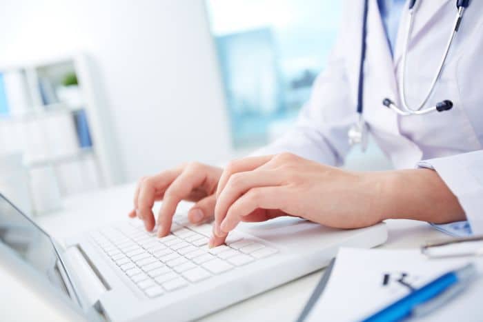 virtual medical receptionist tasks, doctor using laptop