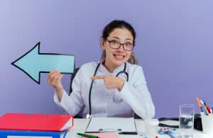 dental receptionist holding an arrow sign