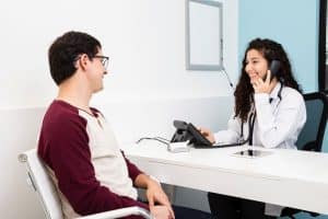 dental receptionist talking to a holding a telephone