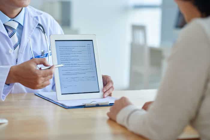 how medical transcription improves patient safety, doctor with digital tablet