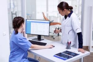 virtual dental receptionist two woman in front of monitor