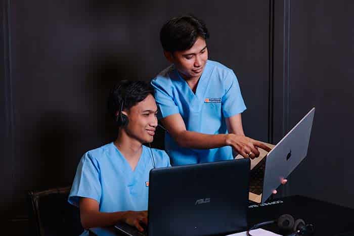 smiling va pointing at the laptop