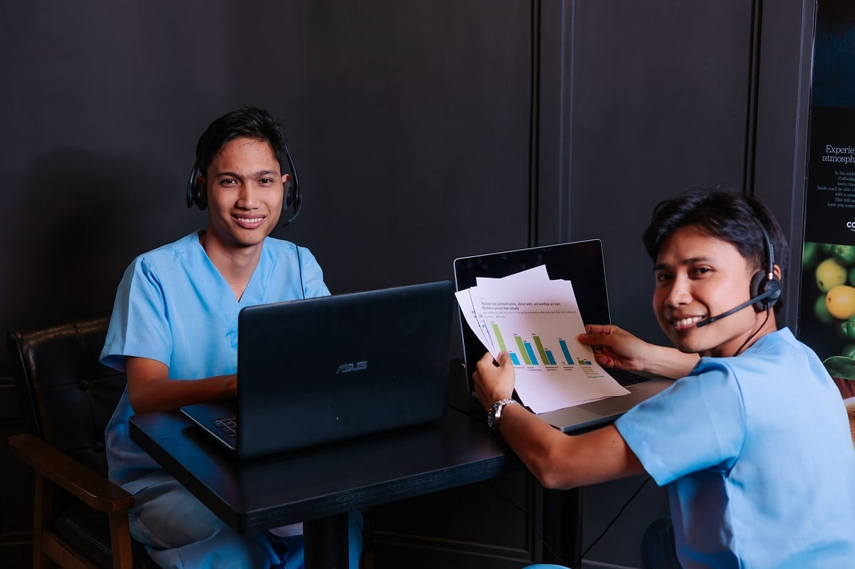 Benefit verification authorization services with wo men in medical scrubs and headsets work on laptops