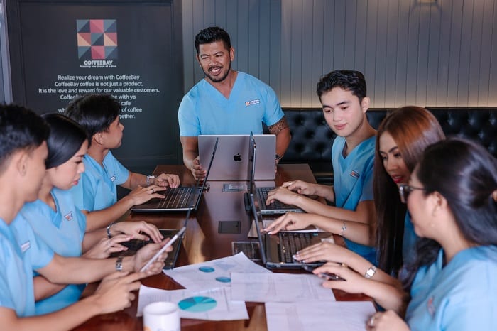 pediatrics medical billing services with a team in medical scrubs collaborates around a table with laptops and documents.