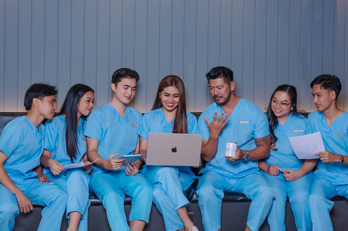 why busy doctors are hiring virtual executive assistants, a group of doctors reviewing information on a laptop and tablet