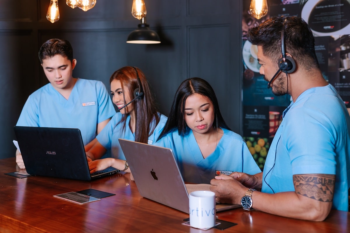 Denial handoff acknowledgement exception recovery support team of virtual medical assistants wearing headsets collaborating at laptops